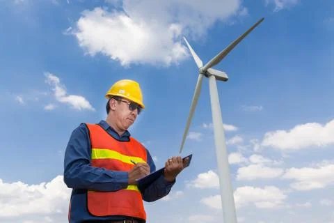 Electric Engineer writing report under Wind turbine power Generator Stock Photos