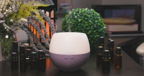 Electric Essential Oils Aroma Diffuser Surrounded by Oil Vials and Flowers Vidéo 111989584