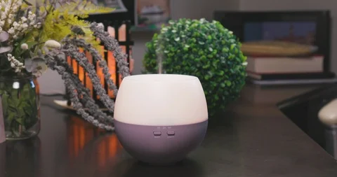 Electric Essential Oils Aroma Diffuser Surrounded by Oil Vials and Flowers Vídeo Stock 111989585