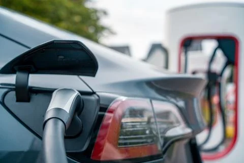 An Electric EV car plugging in and recharging	 Fotos de archivo