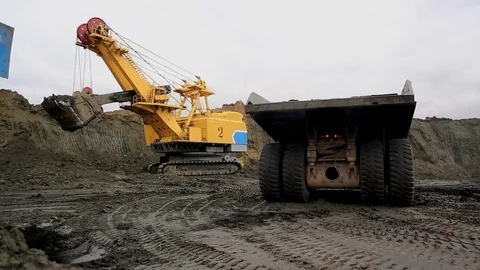 Electric excavator loads quarry dump trucks Stock Footage 77235726