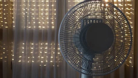 Electric Fan in Front of Sheer Curtains With Warm Fairy Lights, Cozy Ambience Stock Footage 346764890