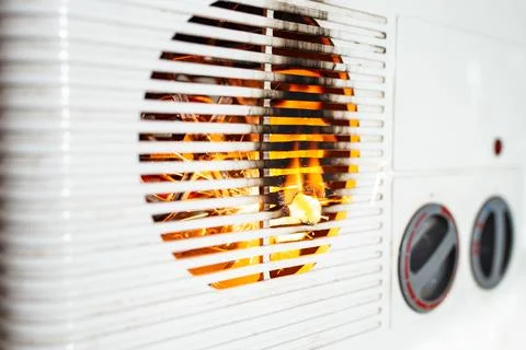 Electric fan heater exploding with sparks and flames, burning plastic,  dom.. Stock Photos