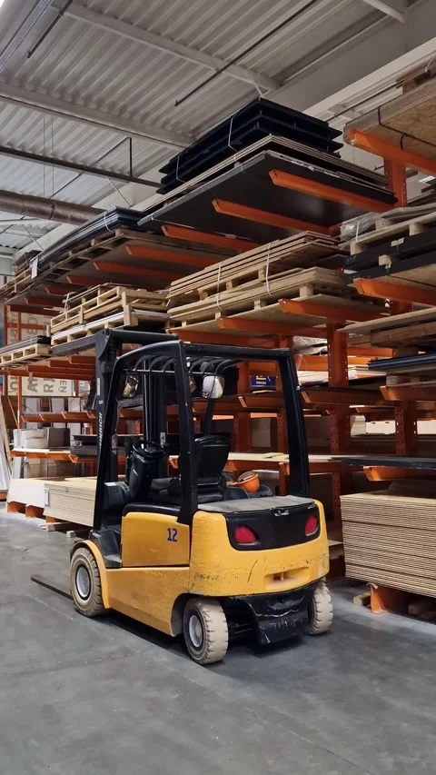 Electric forklift standing between racks with materials Stock Footage 333703795