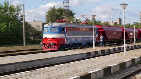Electric freight train transporting cargo passing through a rural railway Stock Footage 345638147