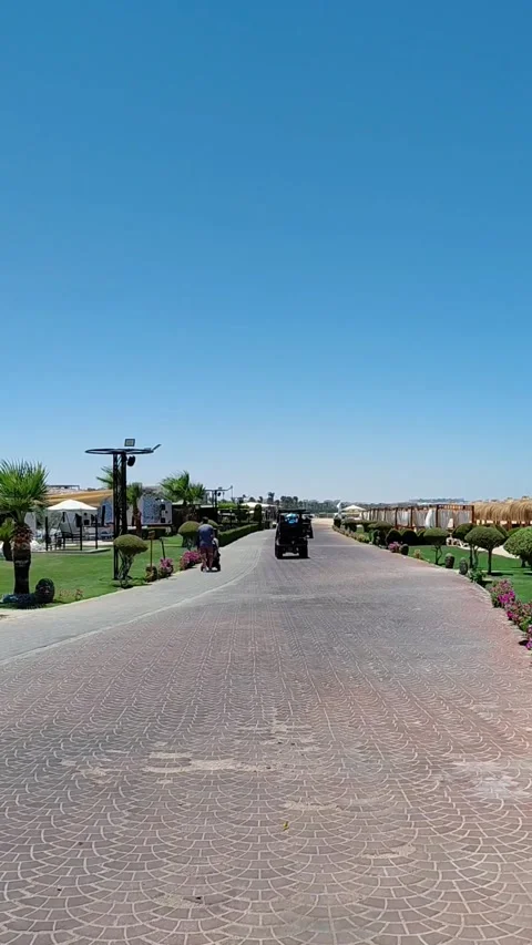 Electric golf cart driving on paved promenade in Sahl Hasheesh resort, Egypt Stock Footage 337532814