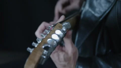 Electric guitar detail: Pull focus from headstock to body as man plays Video stock 310298849