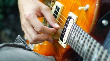 Electric guitar picking in a parc Stock Footage 86141040