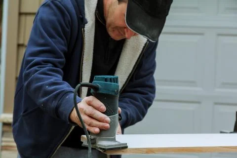Electric hand held power fixed base router with work gloves on wood Stock Photos