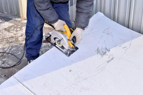 Electric hand tool in the hands of the worker, cutting sheet met Stock Photos