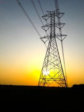 Electric high voltage power post at sunset. Stock Photos