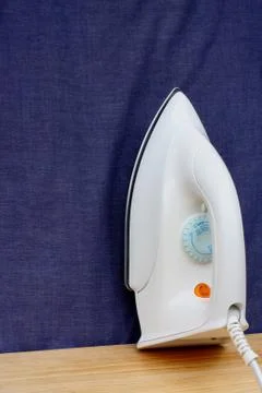 Electric iron  on blue cloth background Stock Photos
