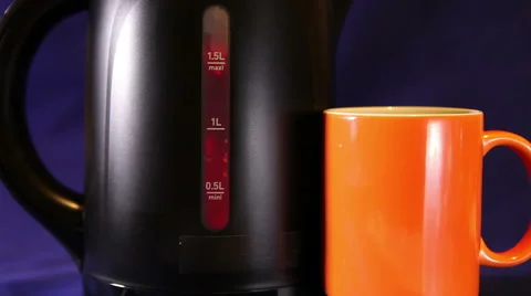 Electric kettle and a mug, measured mark water level red color - a boiling sign Stock Footage