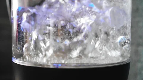 An electric kettle with boiling water bubbling inside. Beautiful lighting Stock Footage 129045908