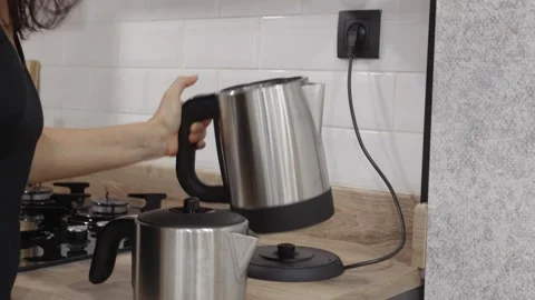 Electric kettle boiling water on kitchen counter Video stock 325960764