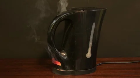Electric kettle on fire, flames and sparks, black smoke. Cause of fire in the fl Stock Footage 289179026