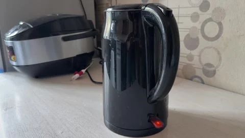 Electric kettle on kitchen counter with multicooker in background, hot water Stock Footage 337120023