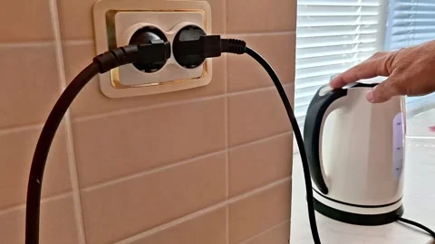 Electric Kettle Plugged Into Dual Wall Outlet in Modern Kitchen Vídeos de archivo 340121804