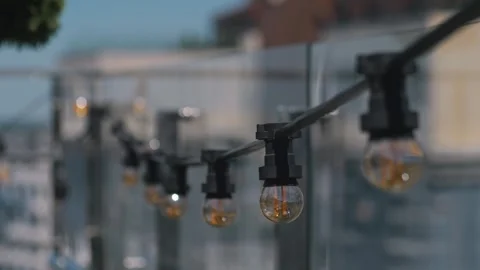 Electric lamp garlands with round shape bulbs hanging in a cafe. Stock Footage 288830893