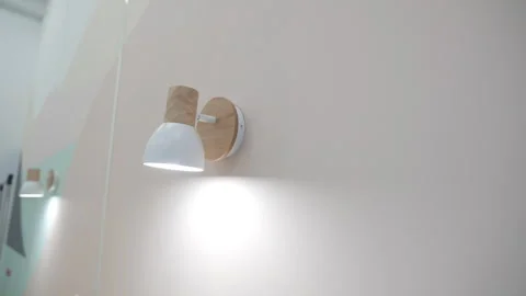 Electric lamp glows hanging on wall of comfortable bedroom 動画素材 314654226
