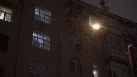 Electric lantern on pole at night during snowfalll against old building 스톡 동영상 103937804