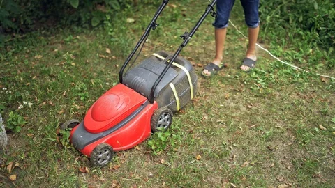 Electric lawn machine during work. Worker is cutting grass in the backyard Stock Footage 119147212