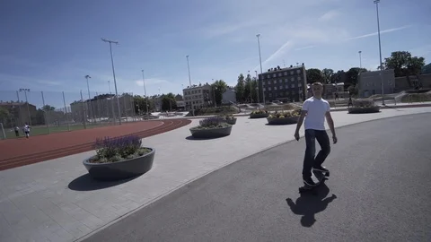 Electric Longboard man in white t-shirt and hat ride on red sport stadium with 動画素材 90814976
