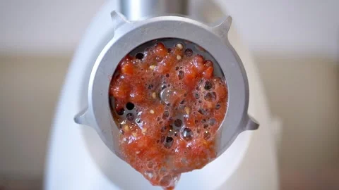 Electric meat grinder processing red tomatoes into juice close up Stock Footage 330118330