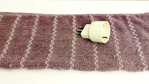 Electric Meets Soft: Adapter on Zigzag Towel Close-Up Video stock 317143588