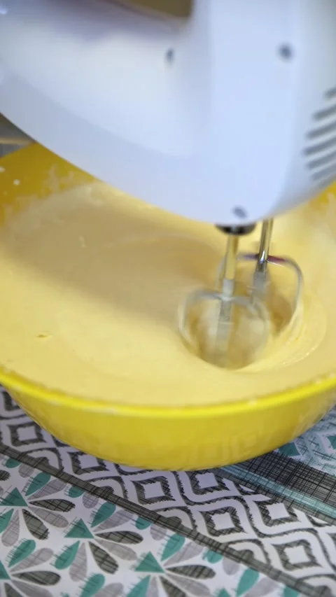 Electric Mixer Beating Yellow Batter in Bright Yellow Bowl Stock Footage 333010287