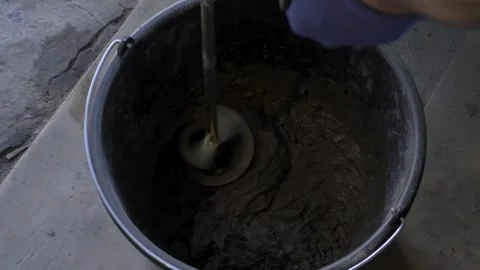 Electric mixer broke down while preparing wall adhesive mixture in bucket Stock Footage 296024395