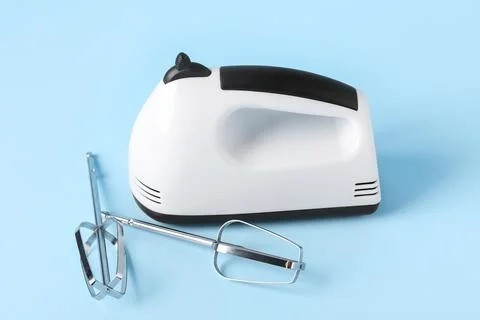 Electric mixer with chrome beaters on blue background Stock Photos