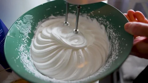 Electric mixer creating a spiral pattern in glossy whipped egg whites Stock Footage 332163955