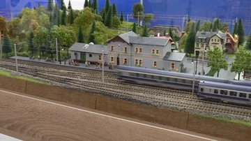 Electric model passenger train moving past station and people miniatures  Stock Footage 85969293