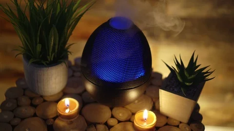 Electric oil diffuser lamp candles on wooden table in room, Aromatherapy Stock Footage 129296187