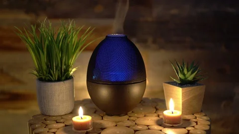 Electric oil diffuser lamp candles on wooden table in room, Aromatherapy Stock Footage 129296325