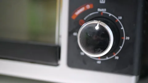 Electric Oven Mechanical Timer Being Adjusted with Rotating Knob Producing Stock Footage 321529052