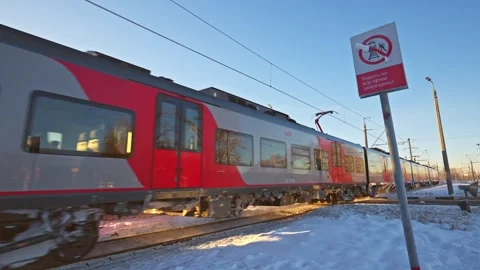 An electric passenger train passes at clear sunny winter day Stock Footage 334896658