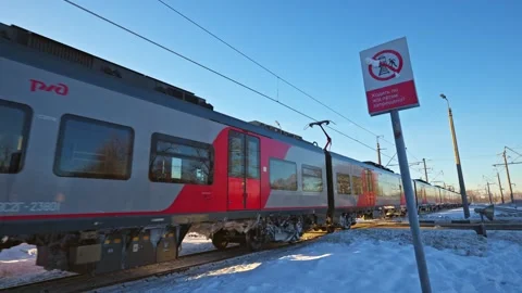 An electric passenger train passes at clear sunny winter day Stock Footage 334896670