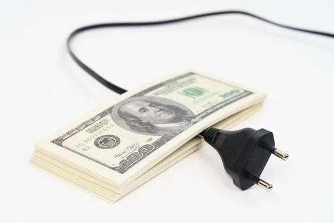 Electric plug and dollars on the table. Stock Photos
