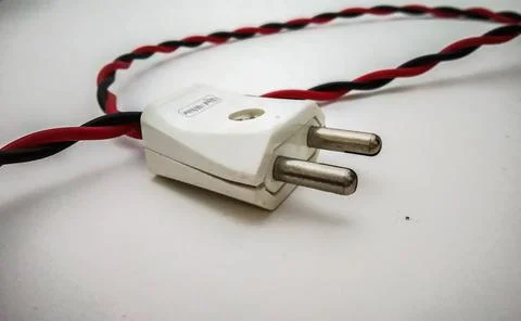 Electric plug close up shot with red wire in a white background Fotos de archivo