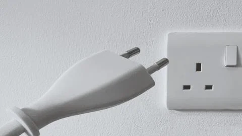 Electric plug connected to wall socket Stock Photos