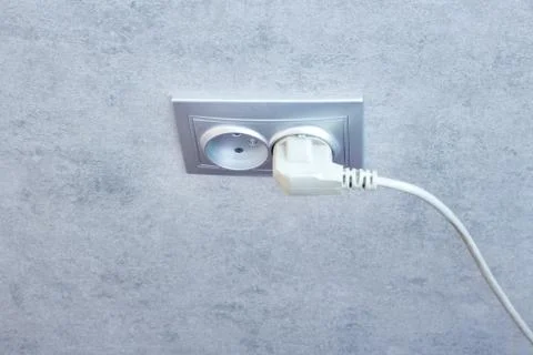 Electric plug in a socket closeup. Small shallow DOF . Stock Photos