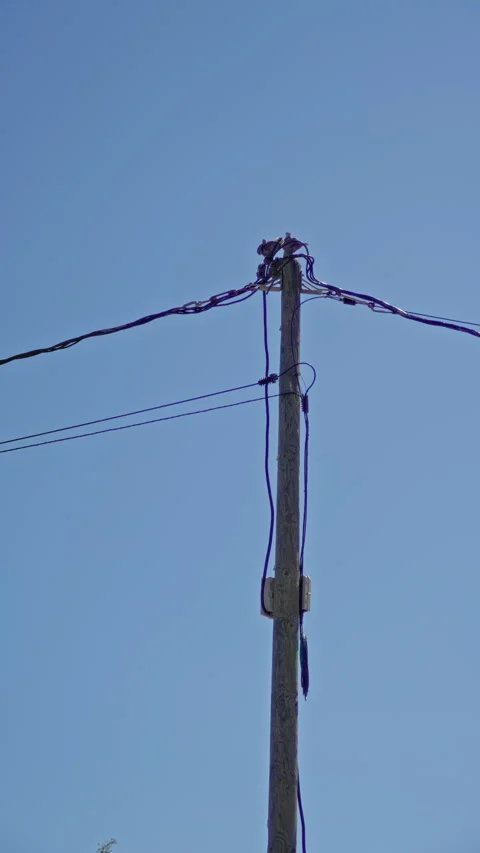 Electric pole with cables under clear blue sky in a sunny outdoor setting, .. Stock Footage 312369597