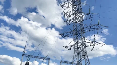 Electric pole with high voltage wires close up against a blue sky Stock Footage 139997785