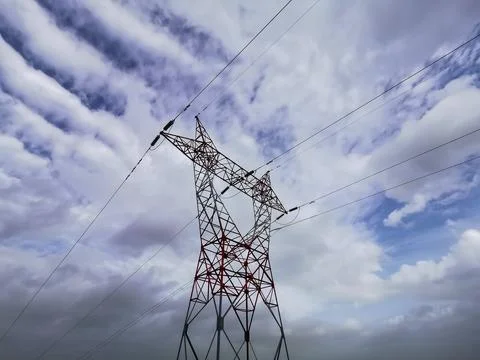 Electric pole under cloudy sky Stock Photos
