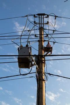 Electric post facing bright blue summer sky with blue sky background Stock Photos