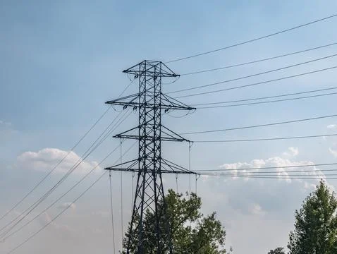 Electric power line going by dirt road in rural landscape Foto stock