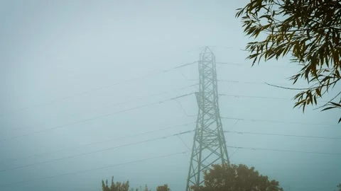 Electric power pole standing in thick fog symbolizing electricity supply Stock Footage 319174256