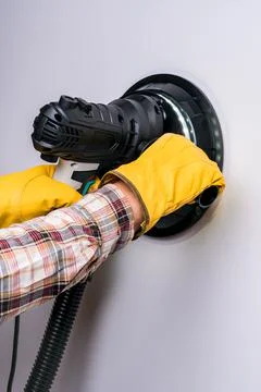 Electric putty grinder in the hands of a worker Foto stock